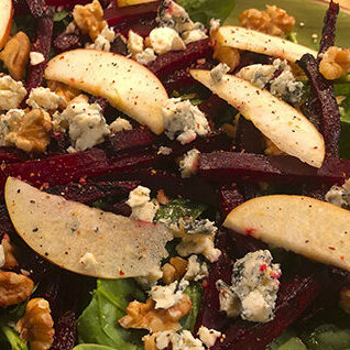 Vin til maden
Servér salaten med en fyldig hvidvin, der komplimenterer rødbedens sødme og blåskimmelostens salte og skarpe karakter. Dette kunne være en [https://www.hjhansen-vin.dk/hvidvin/riesling?instock=OutOfStock&instock=InStock&sortby=Standard&sortdirection=Descending&Country=Tyskland|tysk] eller [https://www.hjhansen-vin.dk/hvidvin/riesling?instock=OutOfStock&instock=InStock&sortby=Standard&sortdirection=Descending&Country=USA|amerikansk] Riesling med en god sødme eller en Gewürztraminer.
Blåskimmelostens fede smag og skarpe karakter fungerer fortrinligt med en sødere hvidvin. Servér en [https://www.hjhansen-vin.dk/soeg?phrase=Beaujolais&instock=OutOfStock&instock=InStock&sortby=Relevance&sortdirection=Descending&ProductGroup=Vin|Beaujolais-vin], hvis du vil underbygge rødbeden og nøddernes sødme. Vinen smager herligt af friske bær og er i den sødere ende.