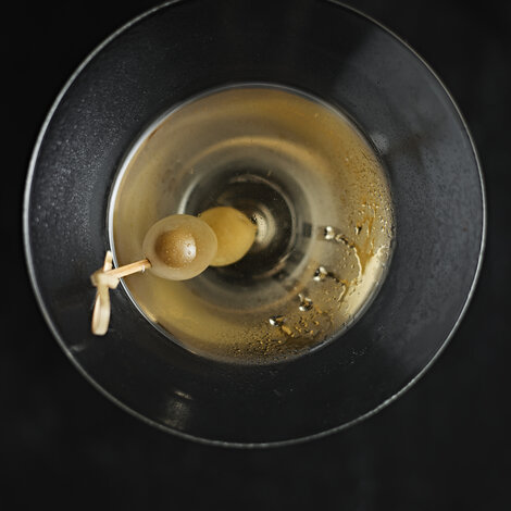 Dirty Martini er på gin eller vodka, tør vermouth og olivenlage. Det er en af de mest populære salte cocktails, der nogensinde er skabt, og selvom den måske lyder moderne, har cocktailen fandtes i over hundrede år.
Faktisk menes Dirty Martini at være opstået i 1901. John O'Connor, som var bartender i New York, opfandt cocktailen og fandt inspiration i den klassiske Martinis olivengarniture - først ved at blande oliven i drinken, og senere ved at tilføje et stænk olivenlage. Bl.a. præsident Franklin D. Roosevelt elskede den og serverede den ofte til gæster i Det Hvide Hus.